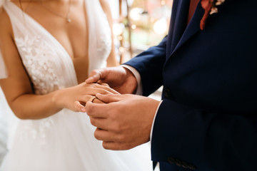 Obraz na płótnie Canvas groom puts bride on wedding ring