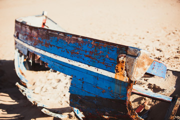 Boat carcass with Blue Paints on the Sandy Beach of Bolonia Spain