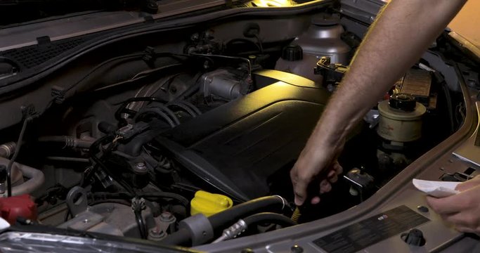 Removing the oil dipstick to check the level, preventive maintenance on the car