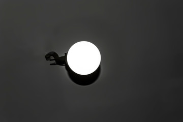 White round lamp shines, weighs on the ceiling