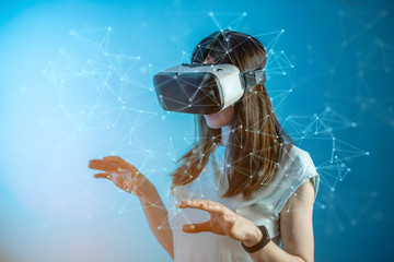 Woman wearing virtual reality glasses watching at 3D visualization in an abstract polygonal grid in a futuristic style.