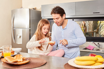 Mädchen schmiert sich zum Frühstück ein Brot