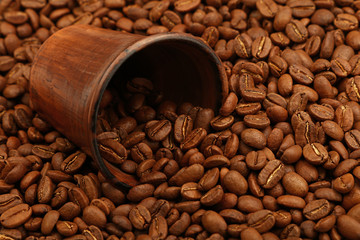 Roasted coffee beans out of brown ceramic cup