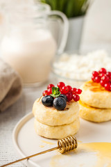 Cheesecakes with berries, cottage cheese and a bottle of milk. Food photo for menus, dairy stores and recipes.