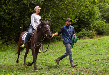 man and woman go horse riding