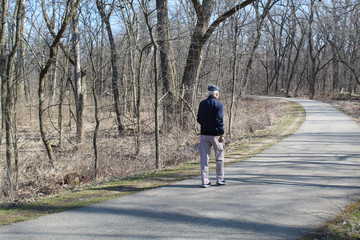 Obraz premium Man with white hair with a flat cap walking in Miami Woods in Morton Grove, Illinois