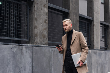 Fototapeta na wymiar Businessman going at work. Businessman with laptop walking on the city street.
