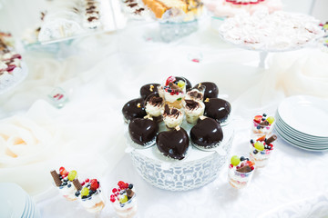 Delicious and tasty dessert table with cupcakes and shots at reception closeup