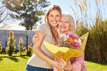 Frau schenkt ihrer Mutter einen Blumenstrauß