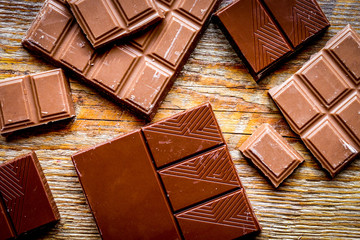 black and milk chocolate bars with mint dark wooden table background top view