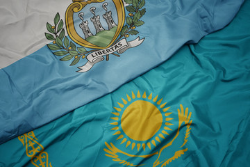 waving colorful flag of kazakhstan and national flag of san marino.