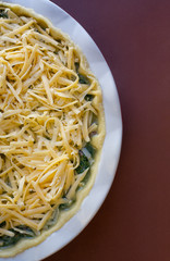 cooking tuna and spinach pie. raw tuna and spinach pie ingredients. Dough. grated cheese. Homemade tuna pie with cheese.