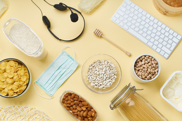 Flatlay with food provision and home office equipment prepared to survive Coronavirus COVID 19 pandemic at the time of cuarentine and home isolation. Pasta, chickpeas, rice, nuts, keyboard