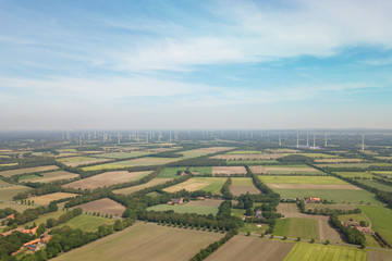 Fototapeta na wymiar Field of windmills with blue sky in Munsterland, Germany