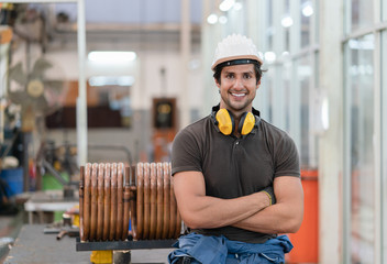 Portrait of male metalworker in protective hard hat smiling and standing relax  take a break at a factory Industrial
