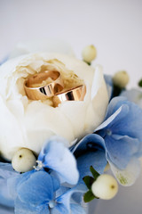 Fototapeta na wymiar Wedding rings in a decorated flower close-up, wedding jewelry, newlyweds rings in flowers, gold rings in white colors