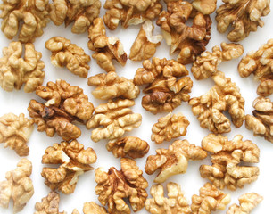 Walnuts on a white background. A pile of peeled dry nuts. Background. Close up. 