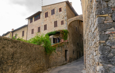 Fototapeta na wymiar Narrow street and its houses, located in San Gimignano, Italy