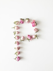 The letter Р is made up of small pink roses on a white background