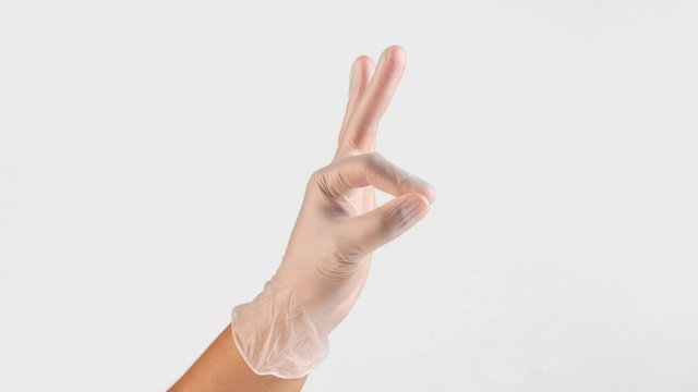 male hand on white in vinyl gloves ok and thumbs up gesture