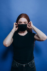 beautiful girl in an antiviral mask on a blue background