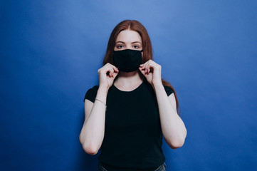 beautiful girl in an antiviral mask on a blue background