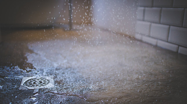 Close up image of water from a shower falling on a shower floor in a luxury bathroom
