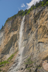 Fototapeta na wymiar Tall waterfall from rocky cliff, Lauterbrunnen, Swiss Alps, vertical