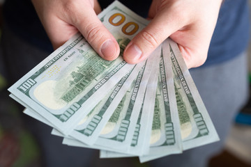 Dollars in man's hands. Profits, savings. Success, motivation, financial flows, wealth. Stack of dollars. 100 us dollars