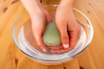 Close up view of a woman washing her hands in a glass bowl 
