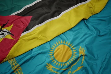 waving colorful flag of kazakhstan and national flag of mozambique.