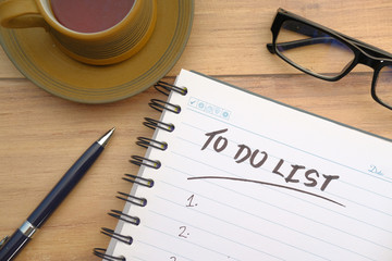  tea cup and notebook with to do list on wooden table 