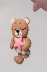 Baby crib mobile - kids toys, on light background.