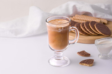 cup of coffee with cream next to the dessert on a white background. copy space