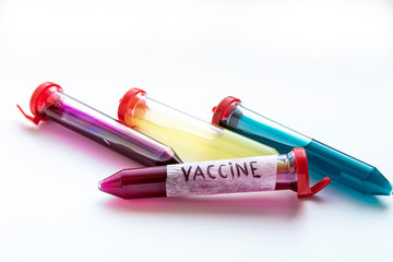 Four test tubes with red, yellow and blue liquid on a white background.