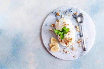  Tasty homemade creamy ice cream with nuts, banana  and mint on stone dish