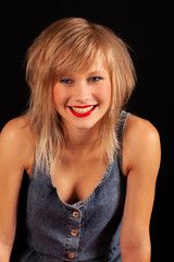 Smiling blonde girl against a black background