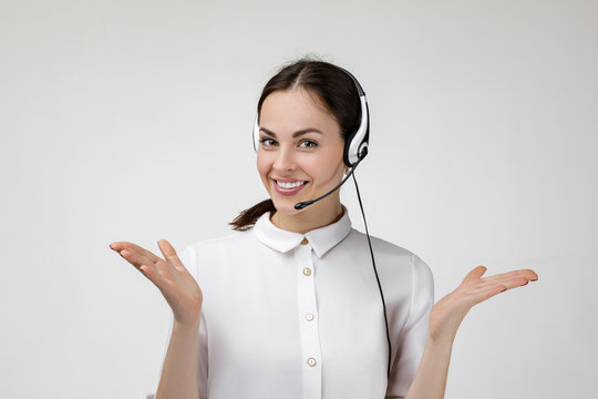 Beautiful smiling woman consultant of call center in headphones on gray background. female customer support operator with headset