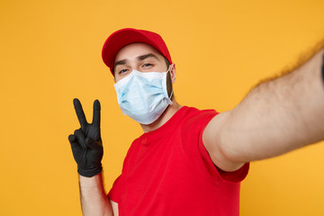 Close up delivery man in red cap blank t-shirt uniform sterile face mask gloves isolated on yellow background studio Guy employee doing selfie shot Service pandemic coronavirus virus 2019-ncov concept
