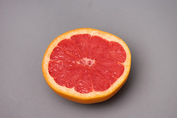 half of grapefruit placed on a gray background