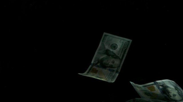 Falling flying american canadian dollar banknotes on a black background in 4K Loopable. High quality falling Dollar banknotes in 4K. Video is Loopable