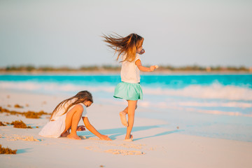 Naklejka premium Adorable little girls have a lot of fun on the beach.