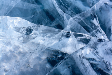 Beautiful cracked ice on the lake. Clear blue ice with white cracks. Horizontal.