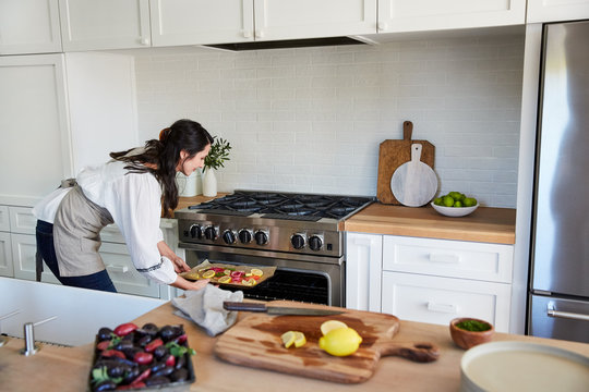 Woman making salmon dinner in kitchen at home