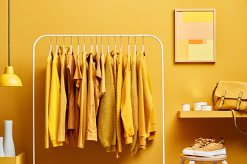 Vivid yellow wardrobe with clothes on rack