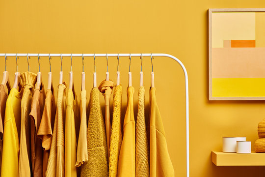 Bright clothes in yellow color on rack