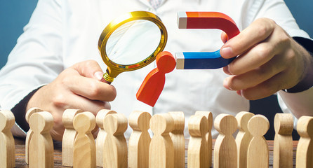 Businessman examines best candidate for work with a magnifying glass. Recruiting new workers,...
