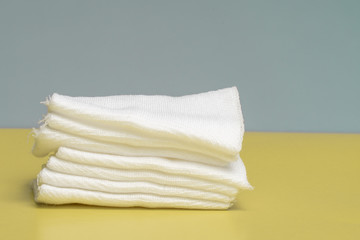 sterile gauze napkins for injections and dressings are stacked on a yellow table