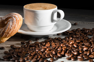white cup of coffee, with coffee beans on the background