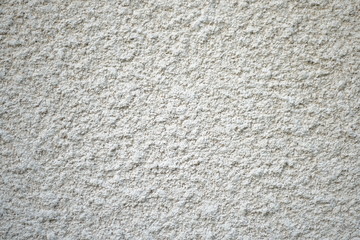 White coarse rough plaster material found on a house wall, texture material